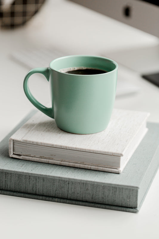Coffee Mug Sitting on a Stack of Books Self Care and Personal Style